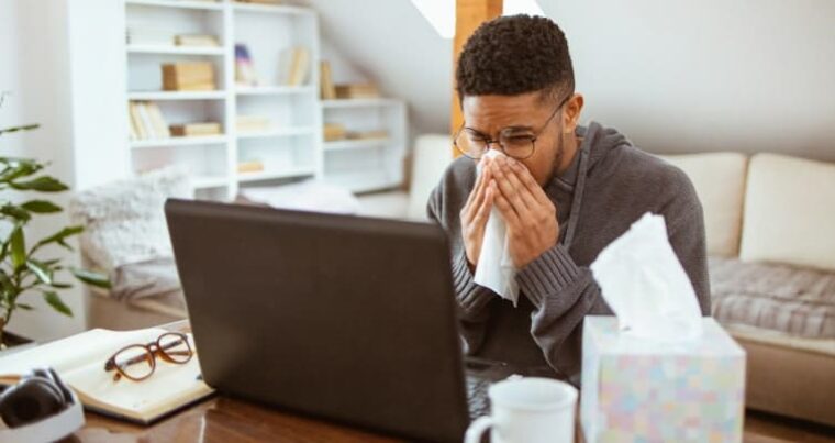 Krankmeldung richtig schreiben: kranker Mann am Laptop